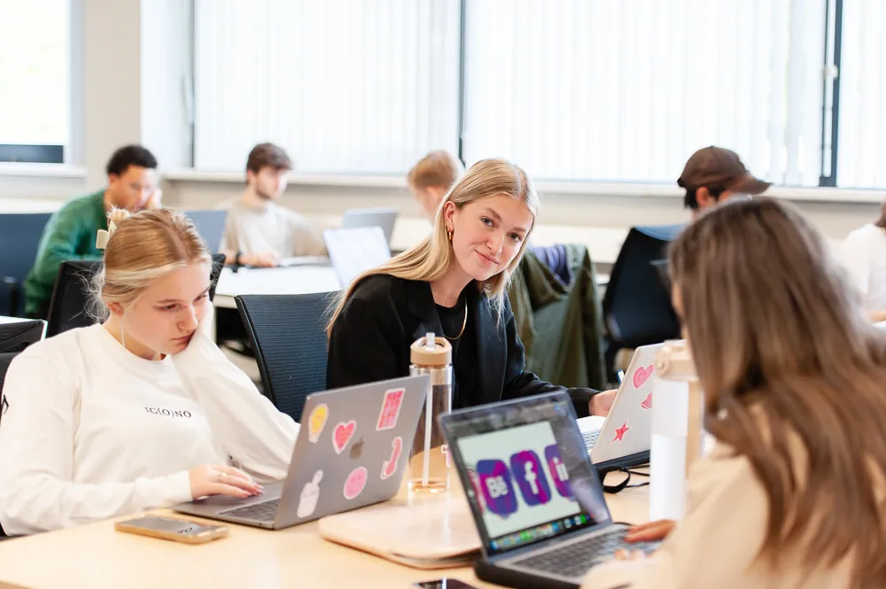 Beperkt aantal plaatsen Klaslokaal waar studenten werken achter hun laptop.